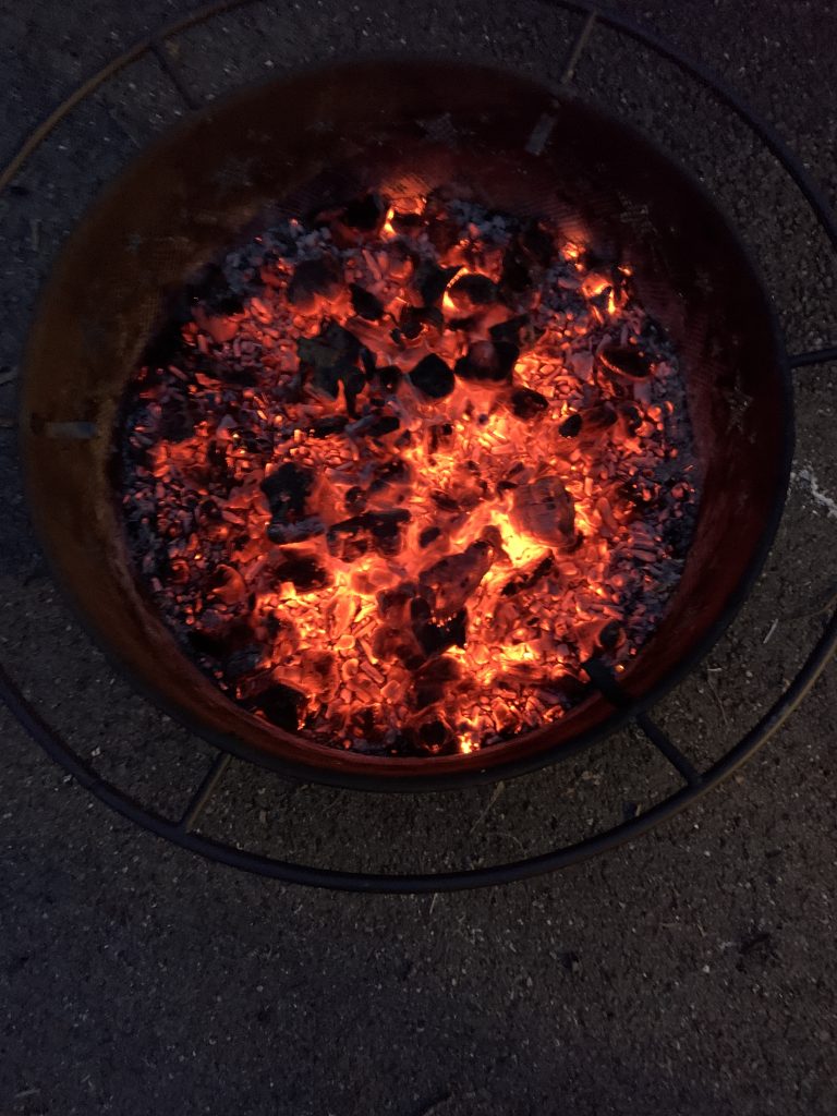 A fire pit filled with red coals.